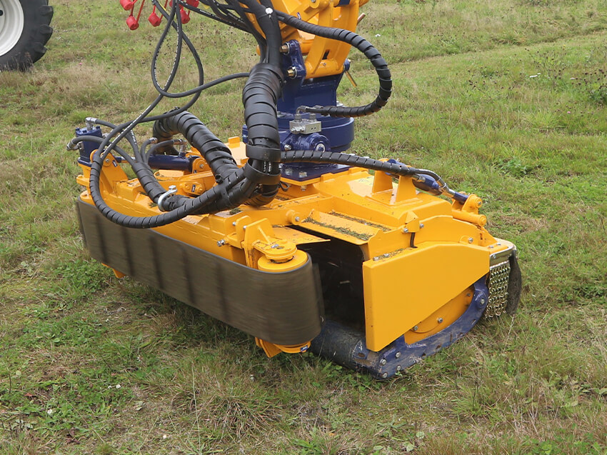 Hydro-Schlegelmulcher mit hydraulischer Klappe und Räumband auf Gras