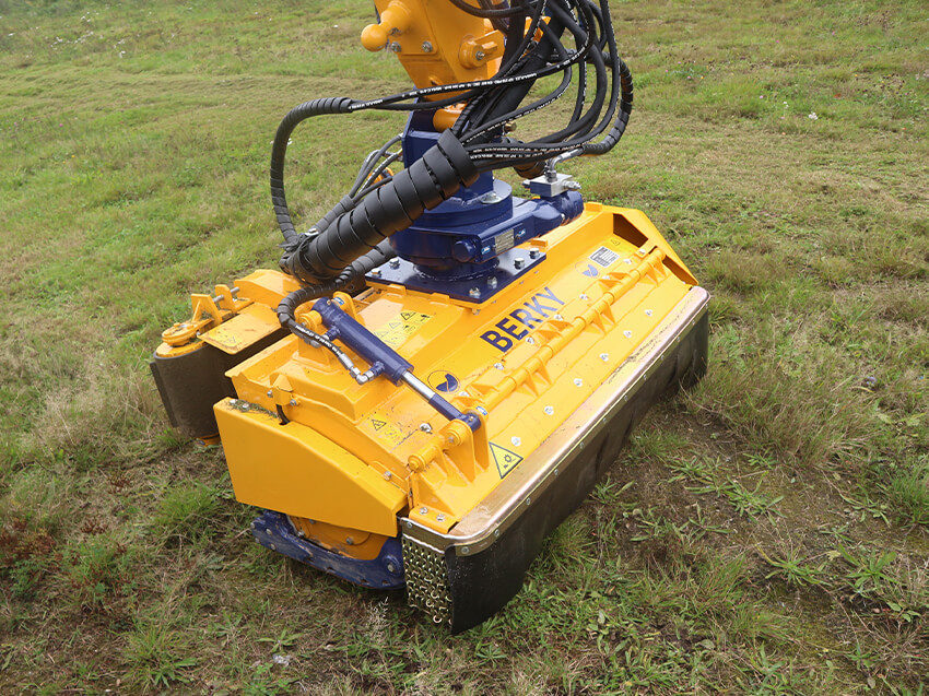 Hydro-Schlegel­mul­cher mit hydrau­lischer Klappe und Räum­band auf Gras